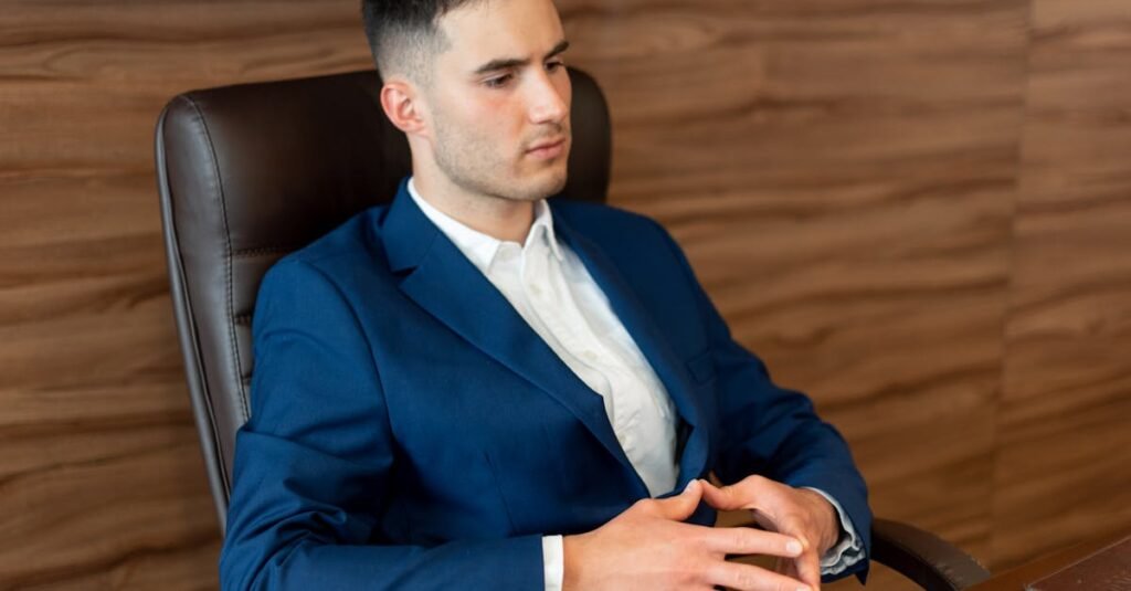 Professional man in a blue suit seated in an office, reflecting a focused business environment.